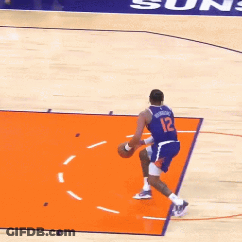 A Basketball Player Wearing A Number 12 Jersey Is Dribbling The Ball GIF