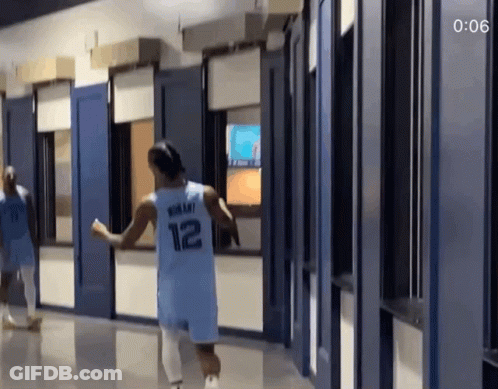 A Basketball Player Wearing A Number 12 Jersey Is Running Down A Hallway GIF