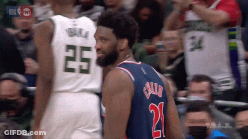 A Basketball Player Wearing A Number 21 Jersey Stands Next To Another Player Wearing A Number 25 Jersey GIF