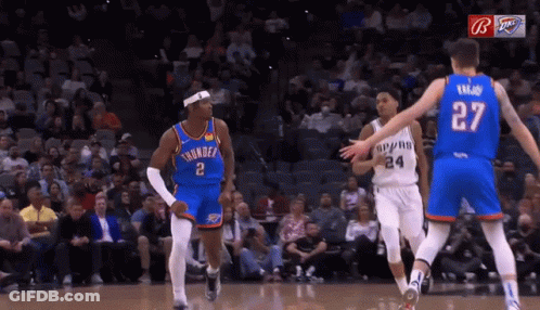 A Basketball Player Wearing A Number 27 Jersey Stands Between Two Other Players GIF