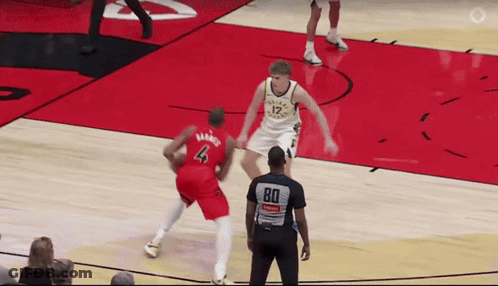 A Basketball Player Wearing A Number 4 Jersey Tries To Block A Player Wearing A Number 12 Jersey GIF