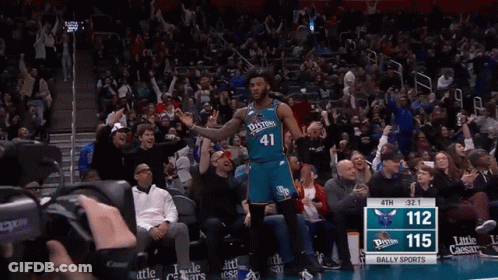 A Basketball Player Wearing A Number 41 Jersey Stands In Front Of A Crowd GIF