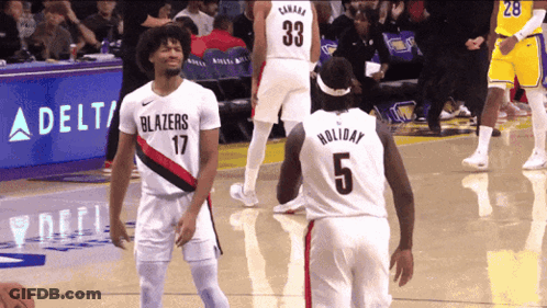 A Basketball Player Wearing A Number 5 Jersey Talks To Another Player Wearing A Number 33 Jersey GIF