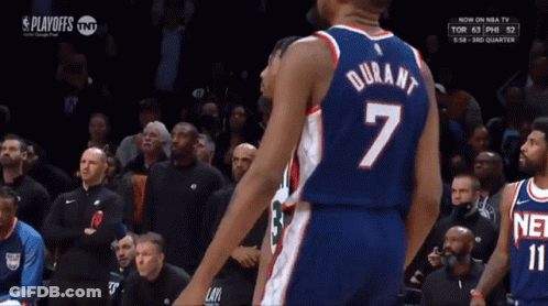 A Basketball Player Wearing A Number 7 Jersey Stands In Front Of A Crowd GIF