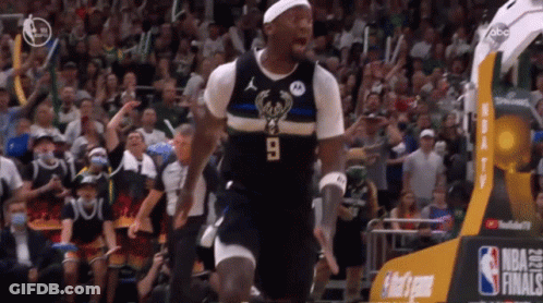 A Basketball Player Wearing A Number 9 Jersey Stands In Front Of A Crowd GIF