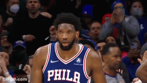 A Basketball Player Wearing A Philadelphia Jersey Stands In Front Of A Crowd . GIF