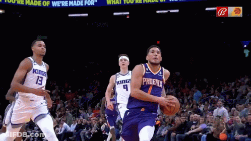 A Basketball Player Wearing A Phoenix Jersey Dribbles The Ball During A Game GIF