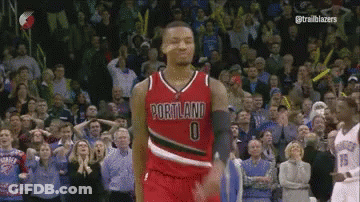A Basketball Player Wearing A Portland Jersey Is Standing In Front Of A Crowd GIF