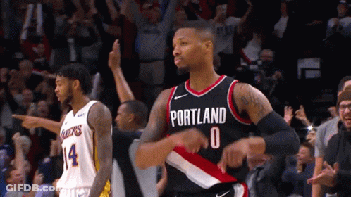 A Basketball Player Wearing A Portland Jersey Stands In Front Of A Crowd GIF