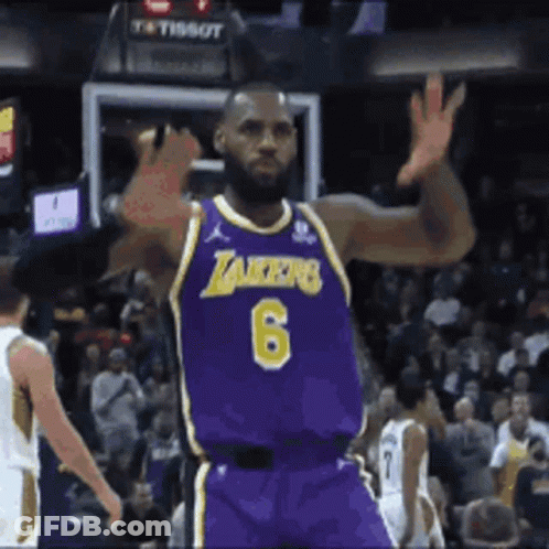 A Basketball Player Wearing A Purple Lakers Jersey Is Waving His Hand GIF