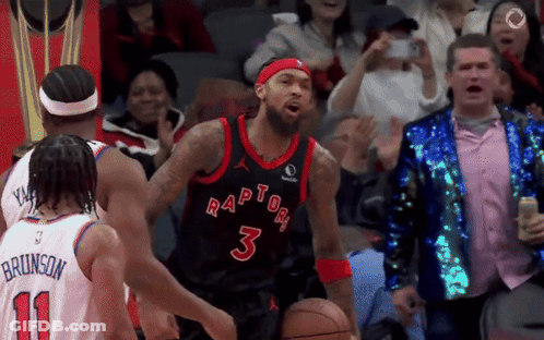 A Basketball Player Wearing A Raptors Jersey Is Dribbling The Ball GIF