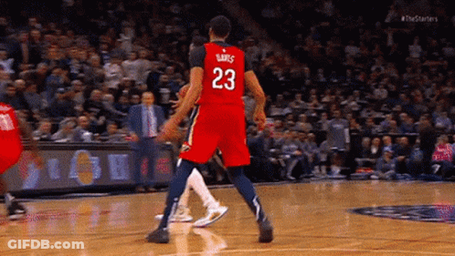 A Basketball Player Wearing A Red Jersey With The Number 23 On It Is Standing On The Court . GIF