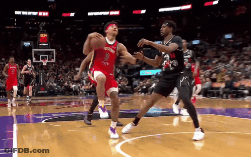 A Basketball Player Wearing A Red Jersey With The Number 8 On It Tries To Block A Player Wearing A Black Jersey GIF