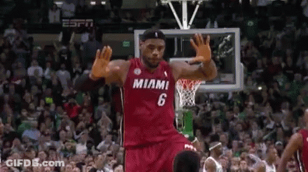 A Basketball Player Wearing A Red Miami Jersey Is Jumping In The Air . GIF