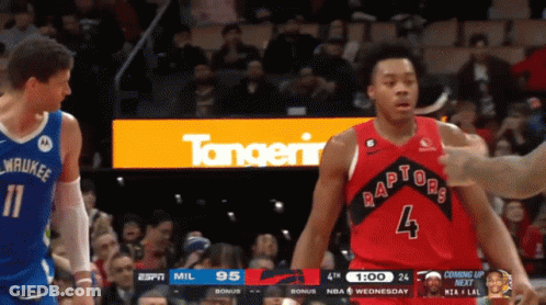 A Basketball Player Wearing A Red Raptors Jersey Stands Next To Another Player GIF
