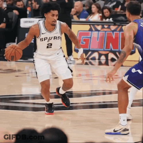 A Basketball Player Wearing A Spurs Jersey Dribbles The Ball GIF