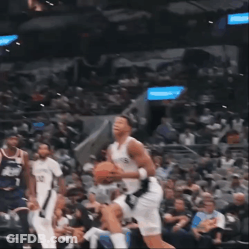 A Basketball Player Wearing A Spurs Jersey Is Jumping To Dunk The Ball GIF