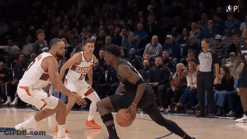 A Basketball Player Wearing A Suns Jersey Dribbles The Ball GIF