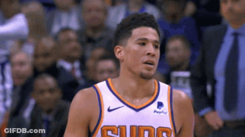 A Basketball Player Wearing A Suns Jersey Looks To The Side GIF