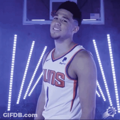 A Basketball Player Wearing A Suns Jersey Stands In Front Of A Basketball Hoop GIF