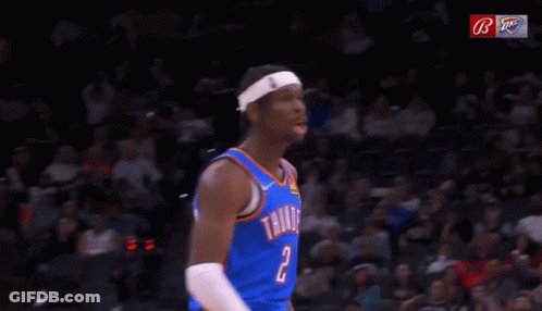 A Basketball Player Wearing A Thunder Jersey Is Yawning In Front Of A Crowd During A Game . GIF