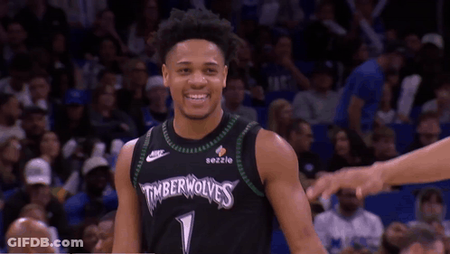 A Basketball Player Wearing A Timberwolves Jersey Smiles At The Camera GIF