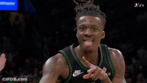 A Basketball Player Wearing A Timberwolves Jersey Stands In Front Of A Tissot Sign GIF