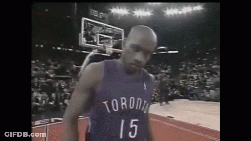 A Basketball Player Wearing A Toronto Jersey Is Standing On A Basketball Court . GIF