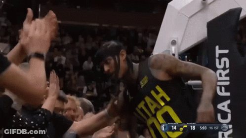 A Basketball Player Wearing A Utah Jersey Is Being Greeted By A Crowd GIF