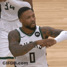 A Basketball Player Wearing A White And Green Jersey With The Number 0 On It . GIF