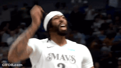 A Basketball Player Wearing A White Mavs Jersey Is Celebrating GIF