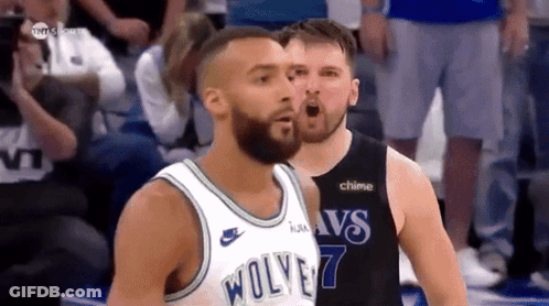 A Basketball Player Wearing A Wolves Jersey Stands Next To Another Player GIF