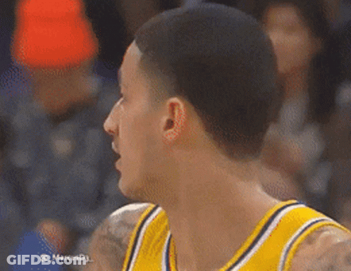 A Basketball Player Wearing A Yellow Jersey Is Looking At Something GIF