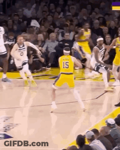 A Basketball Player Wearing A Yellow Jersey With The Number 15 On It Is Dribbling The Ball During A Game . GIF