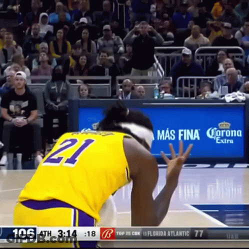 A Basketball Player Wearing A Yellow Jersey With The Number 21 GIF