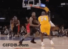 A Basketball Player Wearing A Yellow Jersey With The Number 24 On It Is Being Blocked By Another Player . GIF