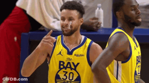 A Basketball Player Wearing A Yellow Jersey With The Number 30 On It Is Standing Next To Another Player . GIF