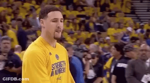 A Basketball Player Wearing A Yellow Shirt Is Standing In Front Of A Crowd Of People . GIF