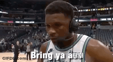 A Basketball Player Wearing Headphones And A Headset Is Talking On A Cell Phone . GIF