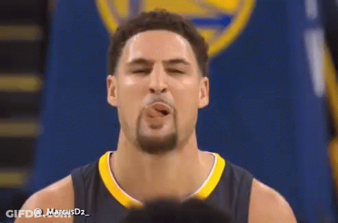 A Basketball Player With A Beard Is Smiling While Wearing A Jersey With A R On It . GIF