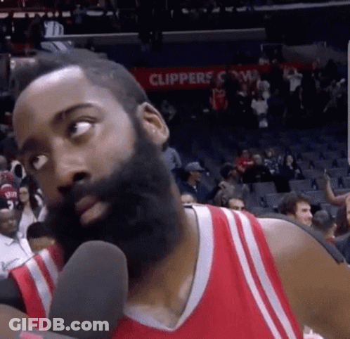 A Basketball Player With A Beard Is Talking Into A Microphone On A Court . GIF