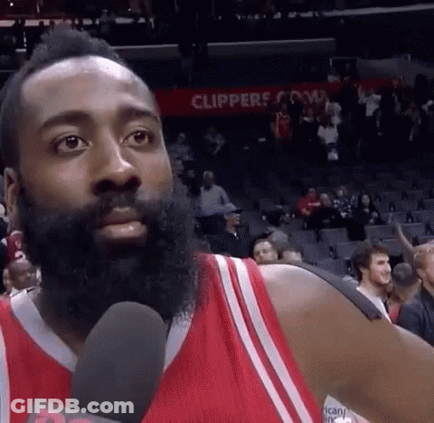 A Basketball Player With A Beard Is Talking Into A Microphone While Standing In Front Of A Crowd . GIF