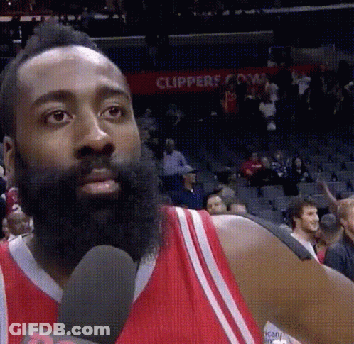 A Basketball Player With A Beard Is Talking Into A Microphone While Wearing A Red Jersey . GIF