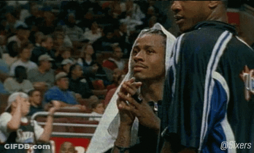 A Basketball Player With A Towel Wrapped Around His Head Stands Next To Another Player . GIF