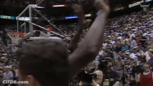 A Basketball Player With His Arms In The Air In Front Of A Crowd With A Scoreboard That Says 11:52 GIF