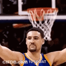 A Basketball Player With His Arms Outstretched In Front Of A Basketball Hoop . GIF