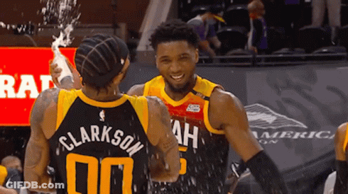 A Basketball Player With The Name Clarkson On His Back Is Hugging Another Player GIF