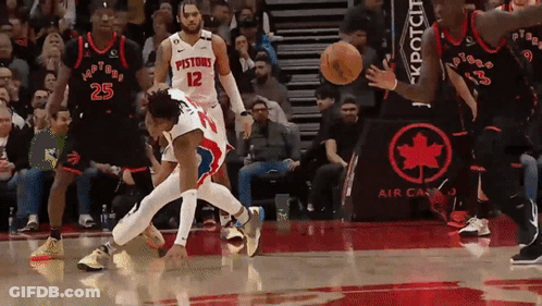 A Basketball Player With The Number 12 On His Jersey Is Being Fouled GIF
