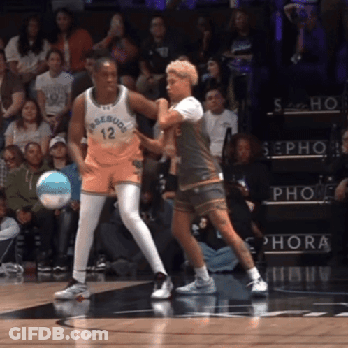 A Basketball Player With The Number 12 On His Jersey Is Playing Against Another Player GIF