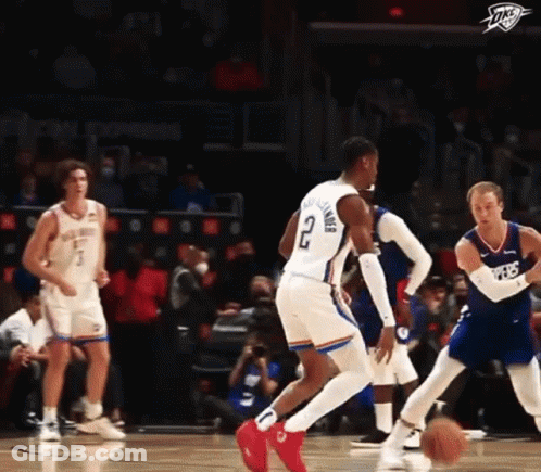 A Basketball Player With The Number 2 On His Shorts Is Dribbling The Ball During A Game . GIF